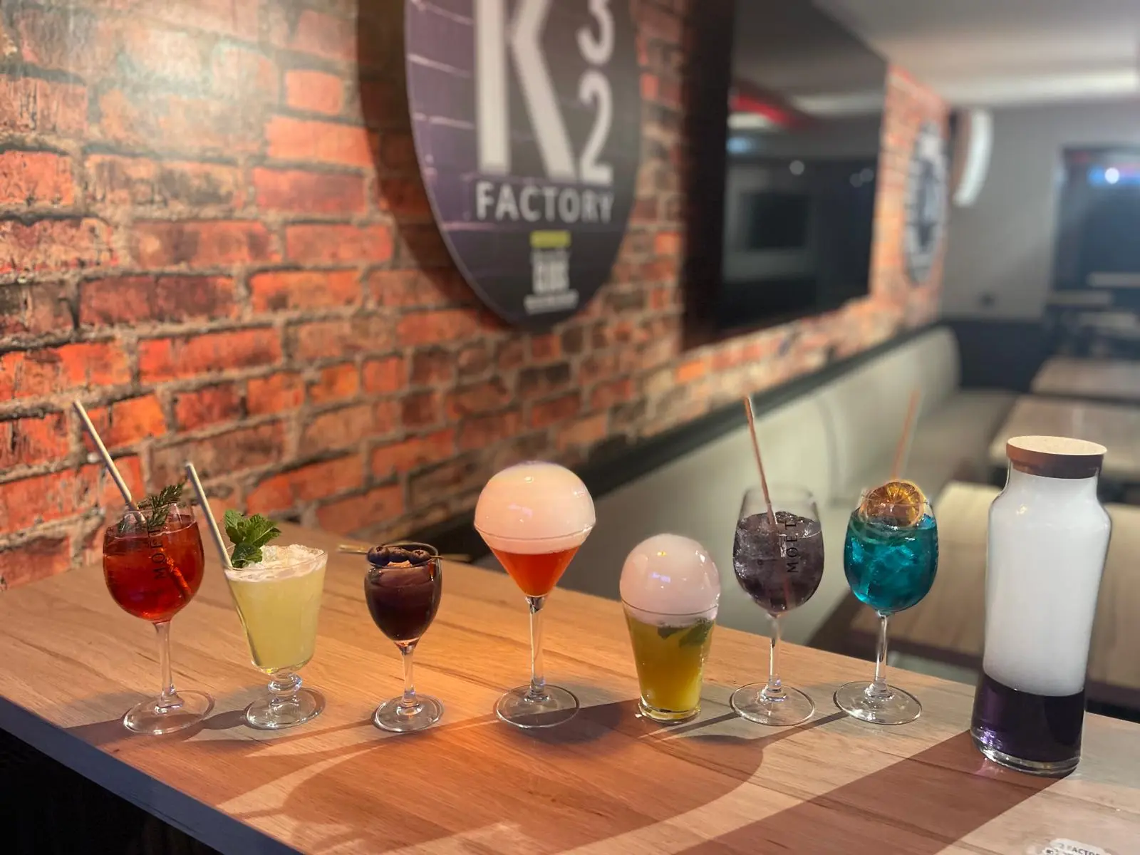 Cocktails aux couleurs variées alignés au bar du K32 Factory à Chaumont