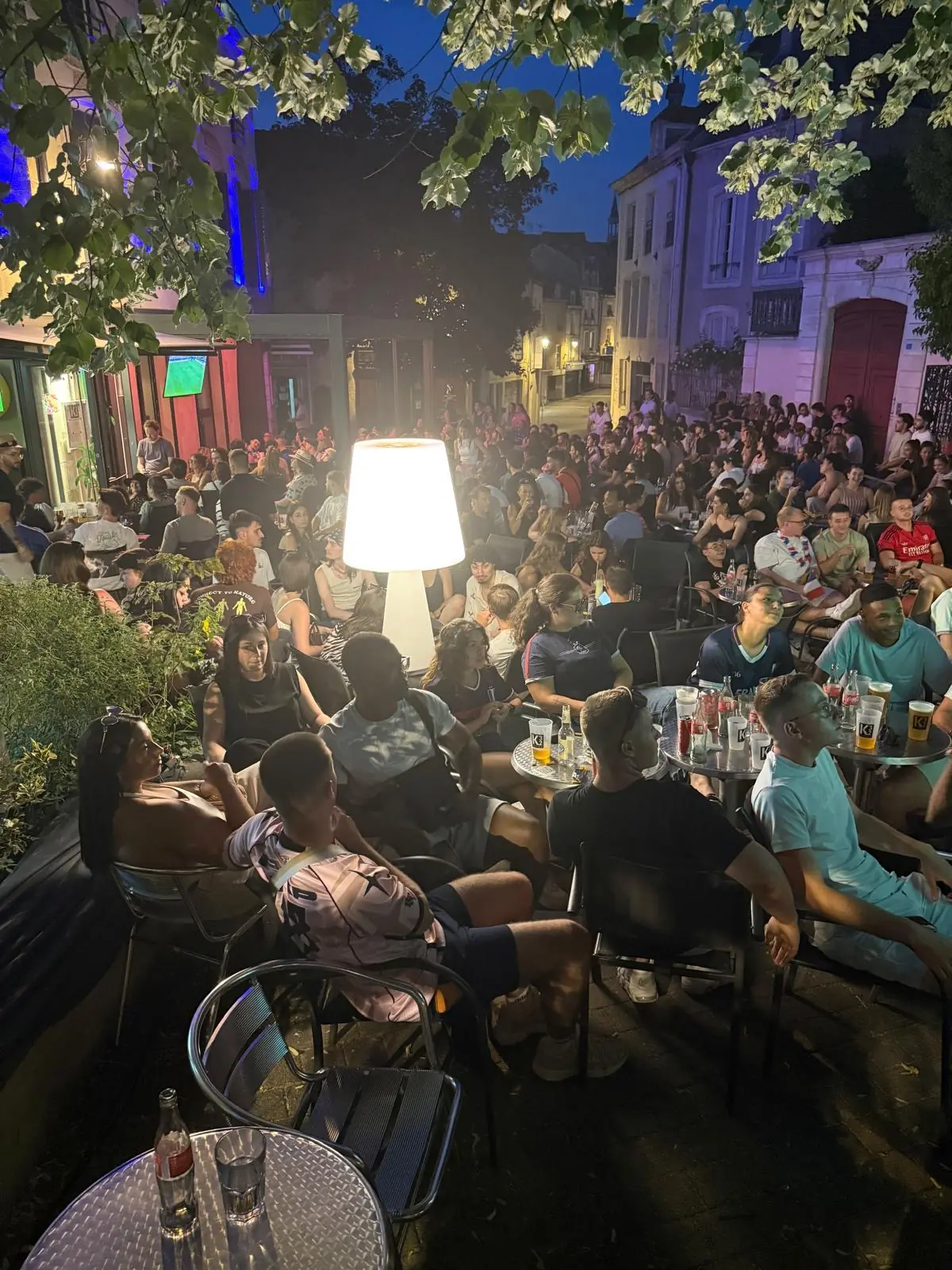 Terrasse du K32 Factory pleine sous les arbres lors d’une soirée à Chaumont